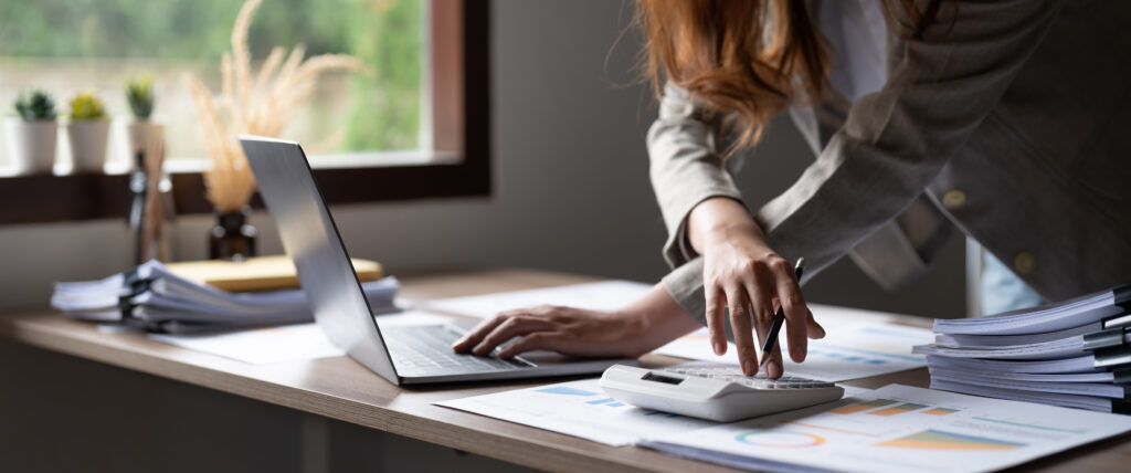 Female accountant working on spreadsheets with a calculator